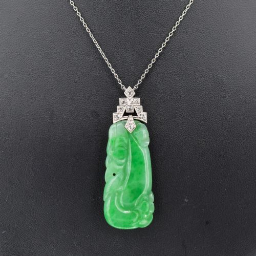 fig 1. An Art Deco carved green jade pendant with geometric platinum and diamond accents on a chain.