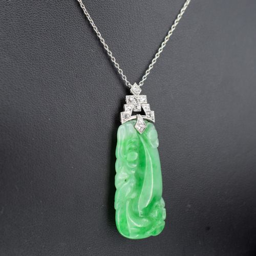 fig 3. An Art Deco carved green jade pendant with geometric platinum and diamond accents on a chain.