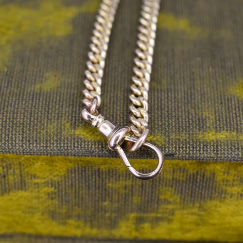 fig 2. An antique 9ct yellow gold uniform curb link chain bracelet with a dog clip clasp arrangement resting on a textured olive display pad.
