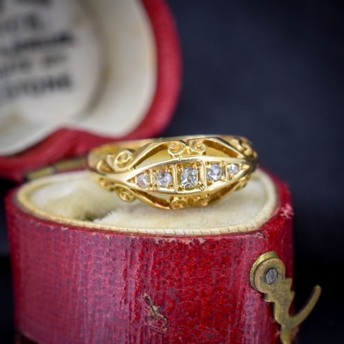 fig 1. An 18ct yellow gold boat-shaped ring set with five graduated diamonds and featuring carved scrollwork along the gallery.