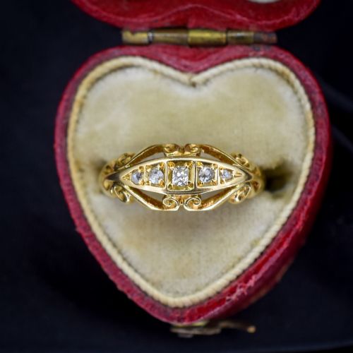 fig 2. An 18ct yellow gold boat-shaped ring set with five graduated diamonds and featuring carved scrollwork along the gallery.
