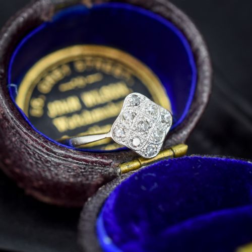 fig 1. An Art Deco 18ct yellow gold ring featuring a platinum square lozenge cluster set with multiple diamonds and fine millegrain details.