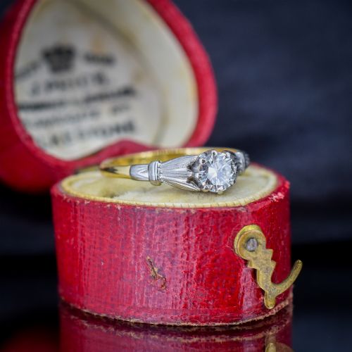 fig 1. An Art Deco diamond solitaire ring featuring a round cut diamond set between detailed, fan-etched shoulders on an 18ct yellow gold band.