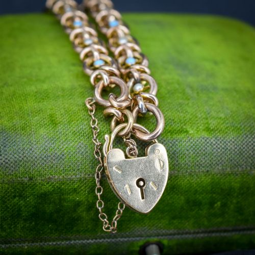 fig 1. An antique rolled gold chain bracelet inset with alternating seed pearls and turquoise cabochons, featuring a heart-shaped padlock clasp with safety chain.