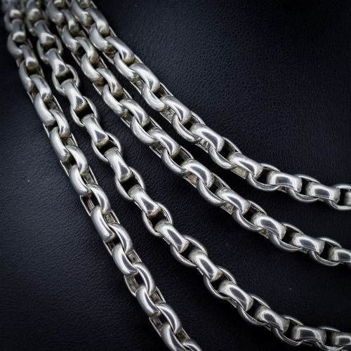fig 2. An antique sterling silver long guard chain featuring belcher links and a dog clip clasp, wrapped in multiple layers on a display bust.