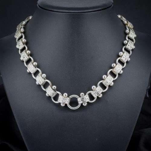 fig 1. An antique Victorian sterling silver collar necklace featuring wide engraved rectangular links accented with silver beads and linked by circular rings.