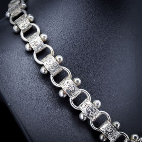 fig 2. An antique Victorian sterling silver collar necklace featuring wide engraved rectangular links accented with silver beads and linked by circular rings.