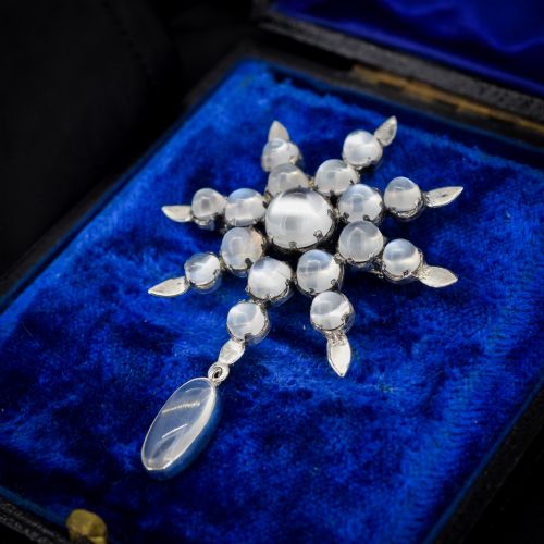 fig 2. A Victorian silver starburst brooch set with round cabochon moonstones and a suspended oval moonstone drop.