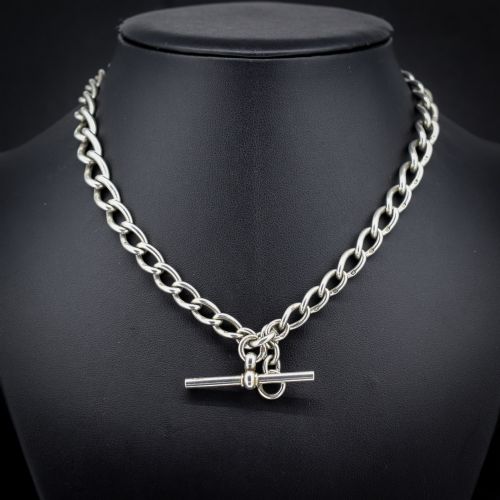 fig 1. An Edwardian sterling silver Albert watch chain featuring heavy oval links, a central T-bar, and a dog clip clasp.