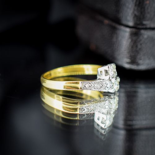 fig 2. An Art Deco eighteen-carat gold and platinum twist ring featuring two round cut diamonds in a bypass setting with millegrain detailed shoulders.