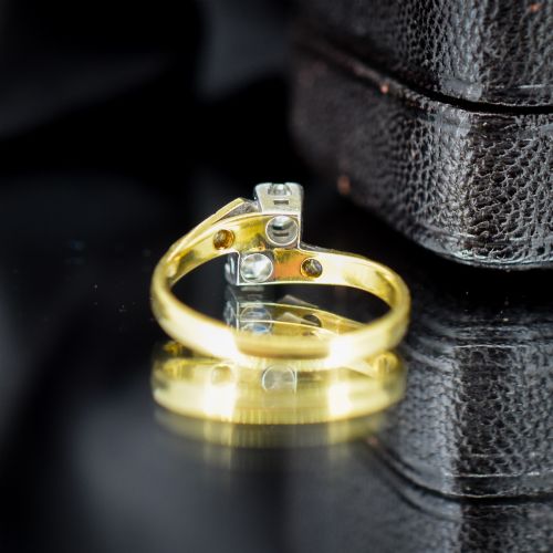 fig 3. An Art Deco eighteen-carat gold and platinum twist ring featuring two round cut diamonds in a bypass setting with millegrain detailed shoulders.