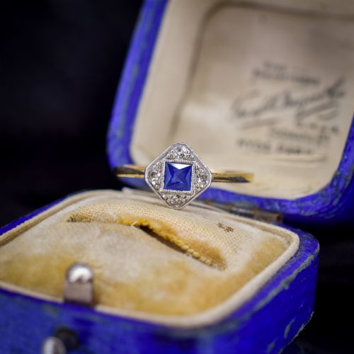 fig 1. An Art Deco ring displaying a square blue sapphire surrounded by diamonds in a diamond-shaped geometric setting on an 18ct yellow gold band.