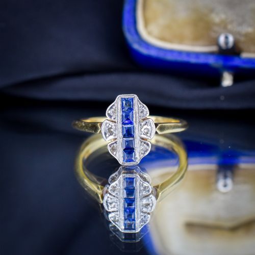 fig 2. An Art Deco 18ct gold ring featuring a central vertical row of square blue sapphires flanked by diamond accents in a navette setting.