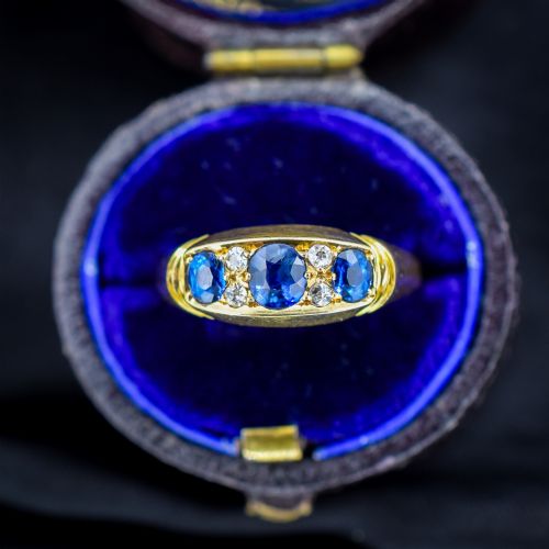 fig 1. An Edwardian 18ct yellow gold boat ring set with three blue sapphires and accent diamonds in a carved setting.