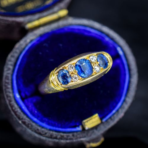 fig 2. An Edwardian 18ct yellow gold boat ring set with three blue sapphires and accent diamonds in a carved setting.