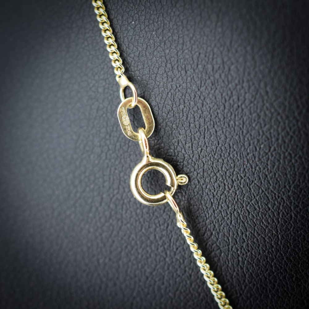 An antique yellow gold necklace featuring a flower cluster pendant set with old cut diamonds suspended on a fine chain. View IV