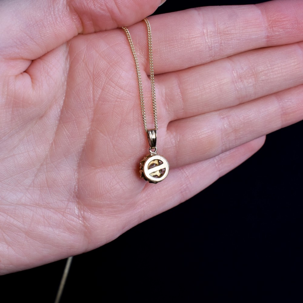 An antique yellow gold necklace featuring a flower cluster pendant set with old cut diamonds suspended on a fine chain. View VII