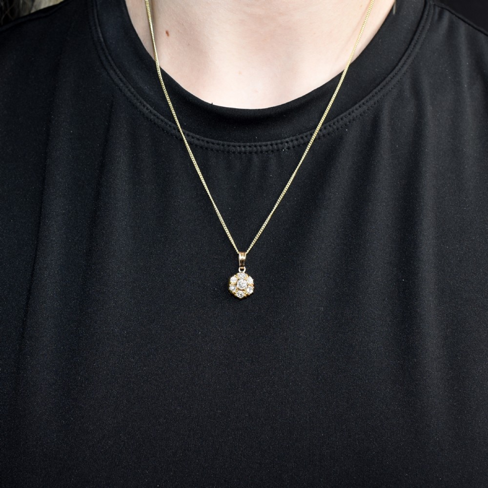 An antique yellow gold necklace featuring a flower cluster pendant set with old cut diamonds suspended on a fine chain. View VIII