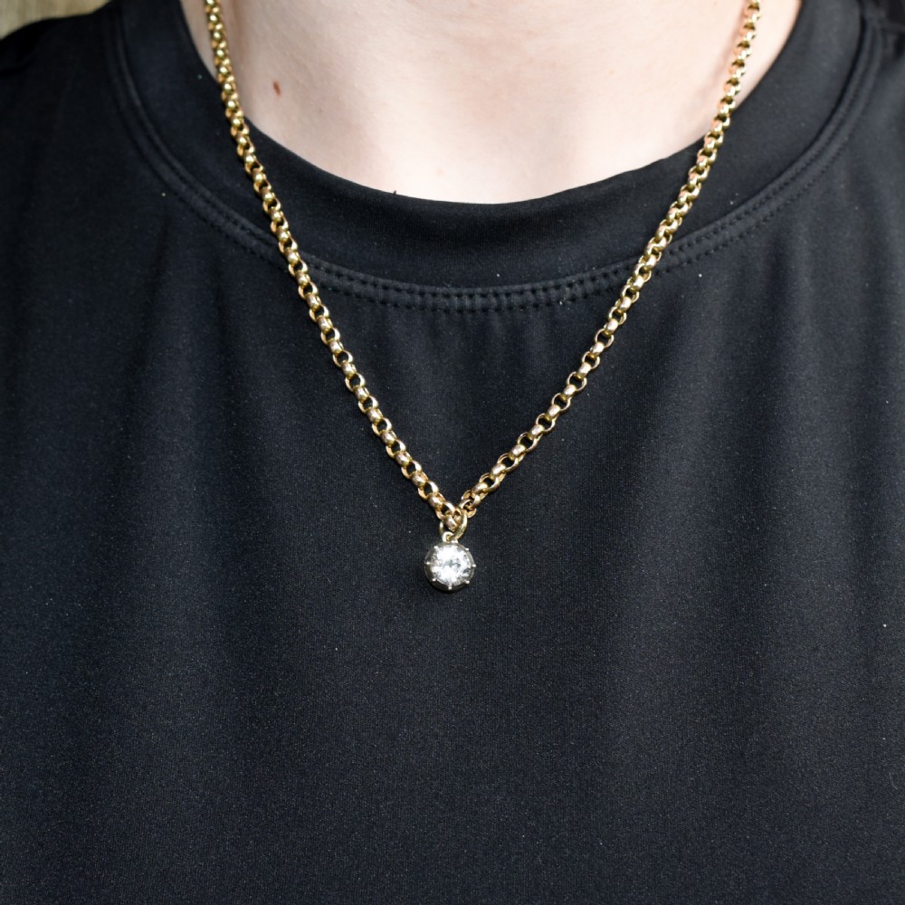 An antique yellow gold necklace featuring a flower cluster pendant set with old cut diamonds suspended on a fine chain. View X