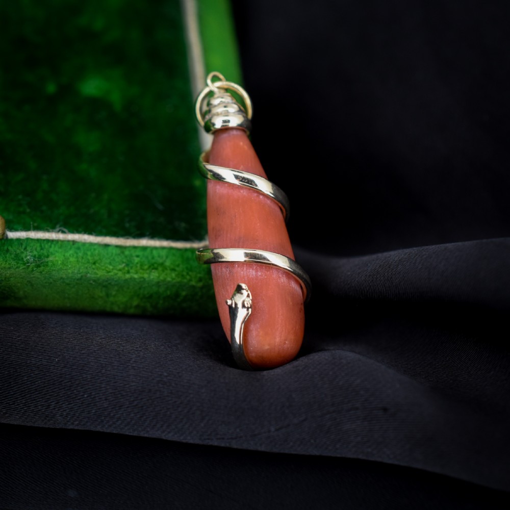 An antique Victorian pendant featuring an orange coral drop wrapped with a coiled 15ct gold snake motif. View III