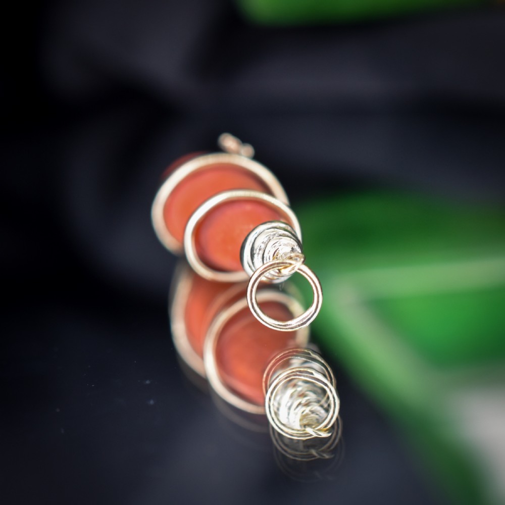 An antique Victorian pendant featuring an orange coral drop wrapped with a coiled 15ct gold snake motif. View IV
