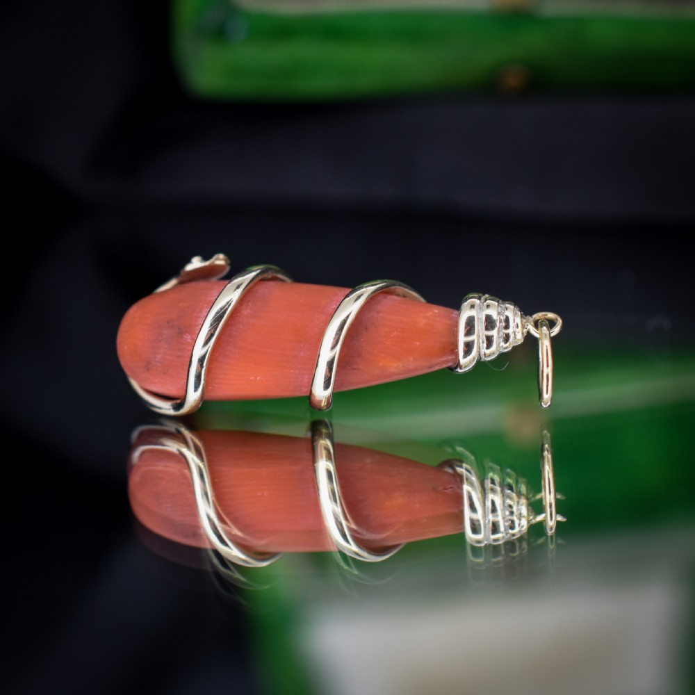 An antique Victorian pendant featuring an orange coral drop wrapped with a coiled 15ct gold snake motif. View V