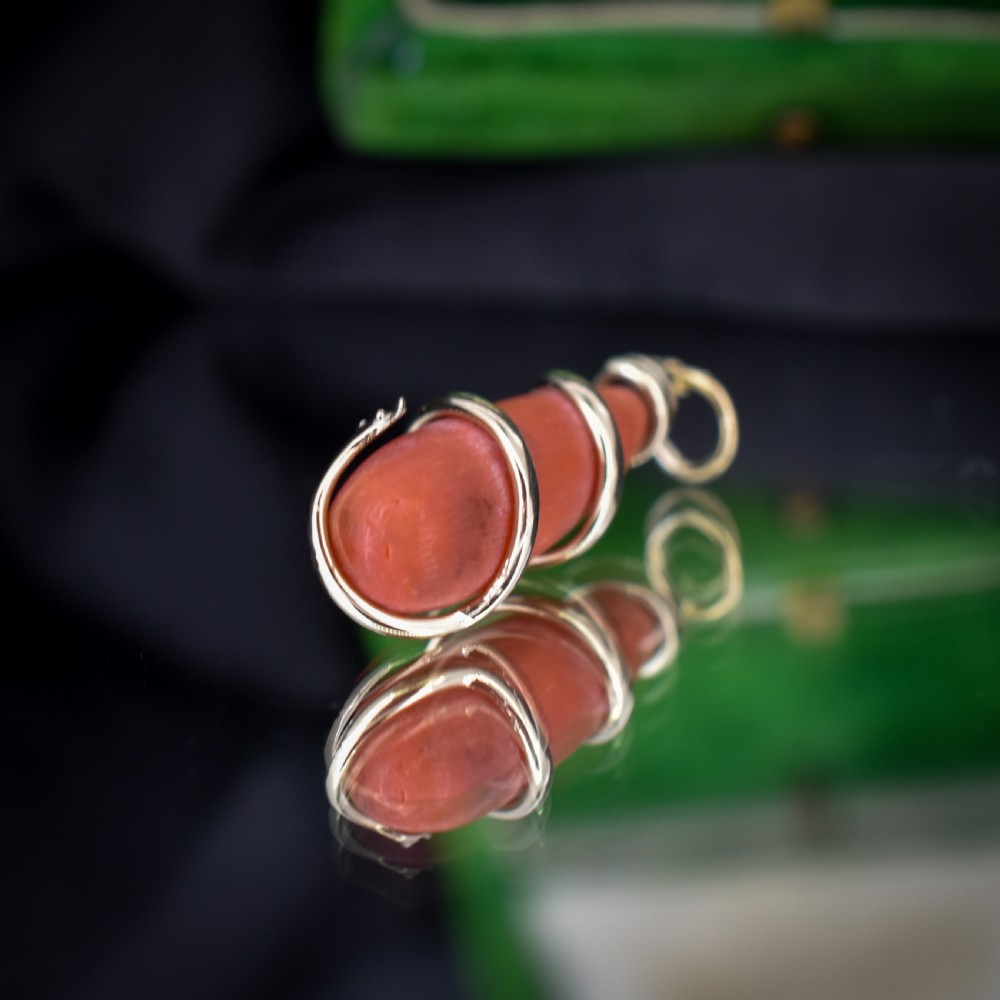 An antique Victorian pendant featuring an orange coral drop wrapped with a coiled 15ct gold snake motif. View VI