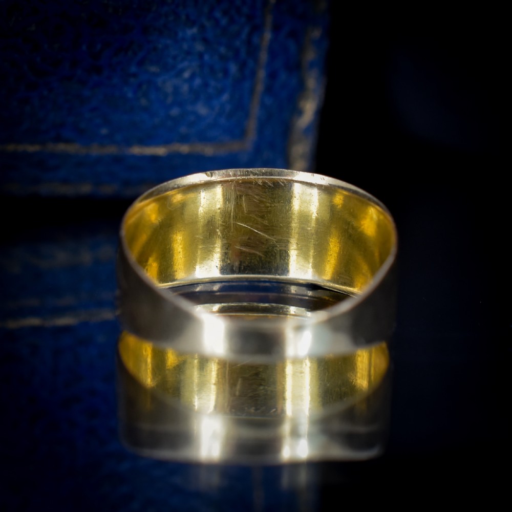 A wide yellow gold band ring featuring raised lettering spelling MIZPAH against a textured background with milled borders. View VII