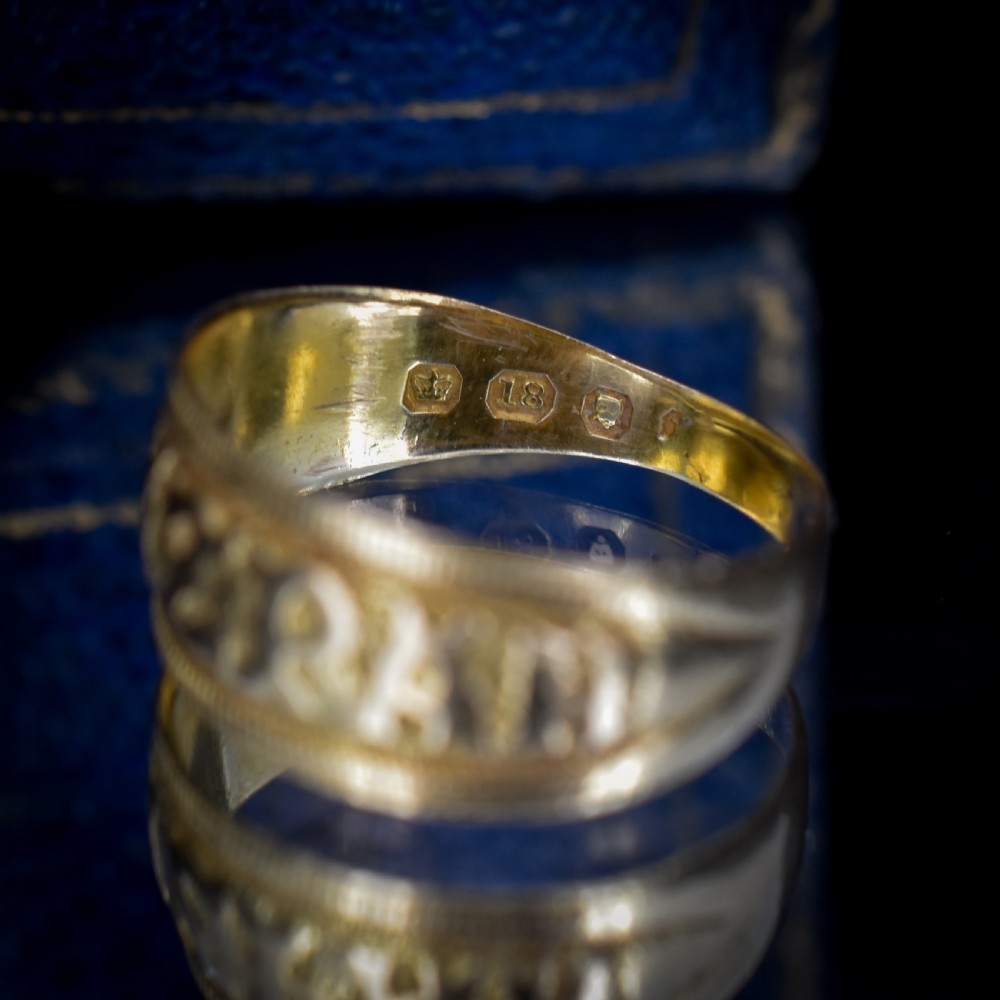 A wide yellow gold band ring featuring raised lettering spelling MIZPAH against a textured background with milled borders. View VIII