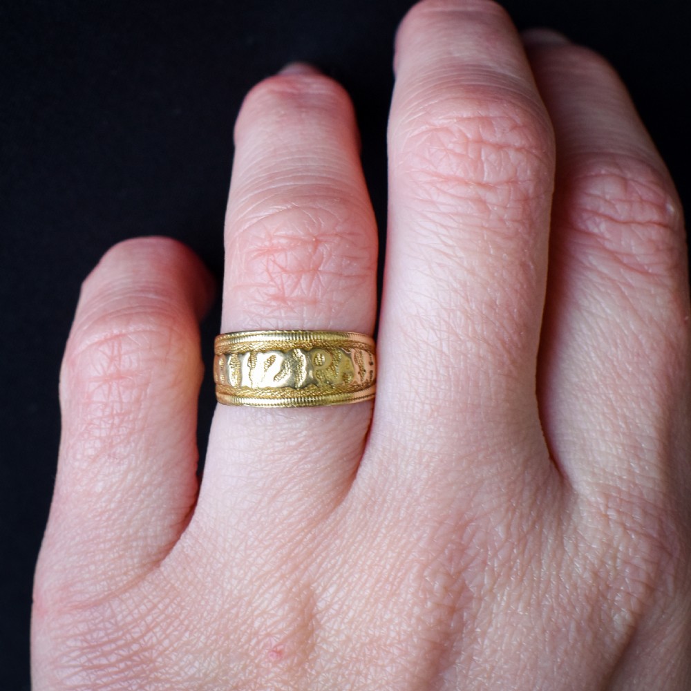 A wide yellow gold band ring featuring raised lettering spelling MIZPAH against a textured background with milled borders. View X