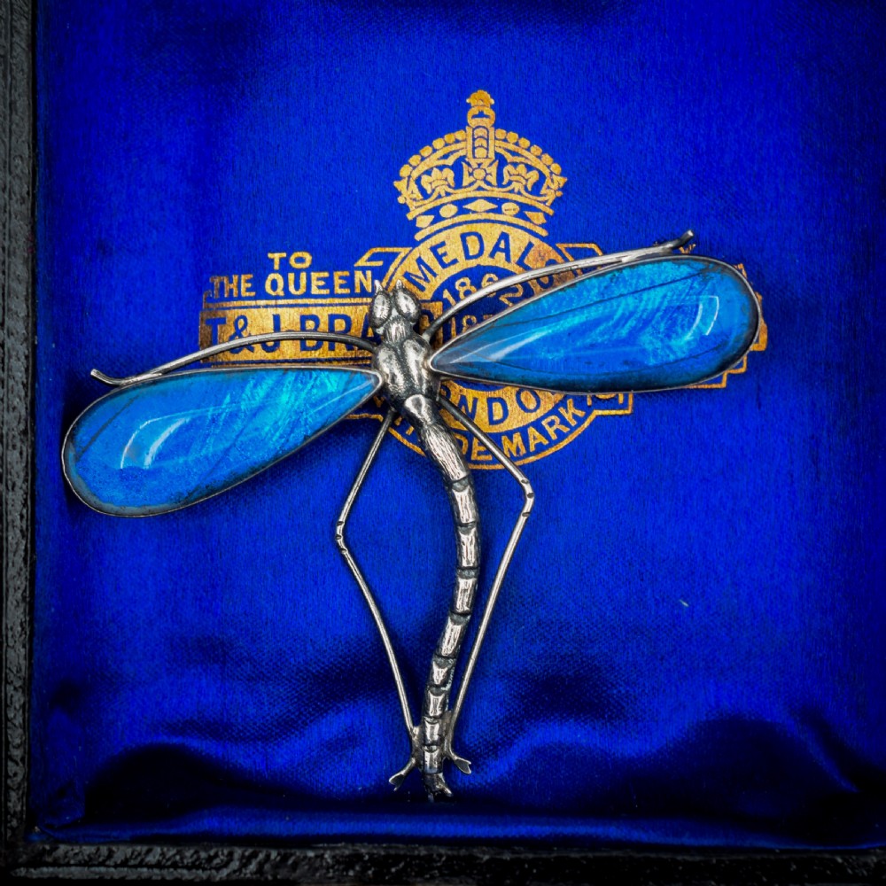 An Art Deco sterling silver brooch designed in the shape of a dragonfly with iridescent blue butterfly wings set beneath glass. View III