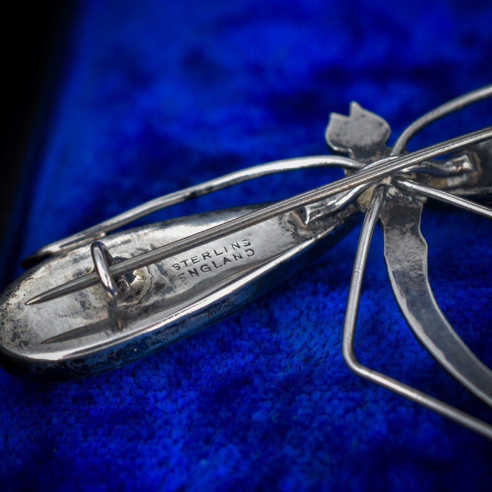 An Art Deco sterling silver brooch designed in the shape of a dragonfly with iridescent blue butterfly wings set beneath glass. View VII