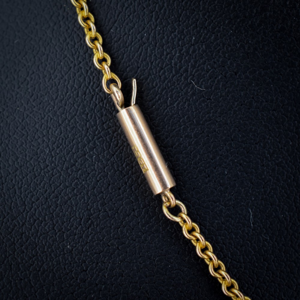 A 15ct yellow gold chain supporting a circular drop pendant featuring an Australian continent map cutout set between two round paste stones. View III