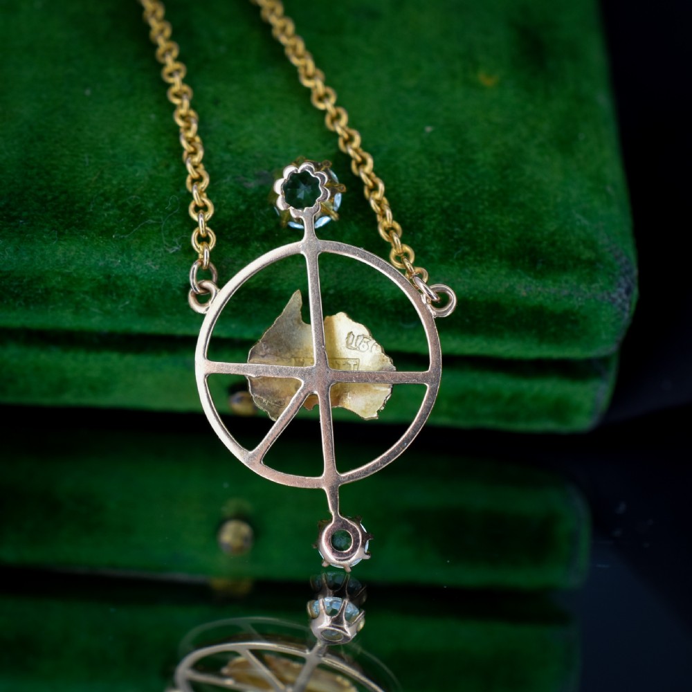 A 15ct yellow gold chain supporting a circular drop pendant featuring an Australian continent map cutout set between two round paste stones. View V