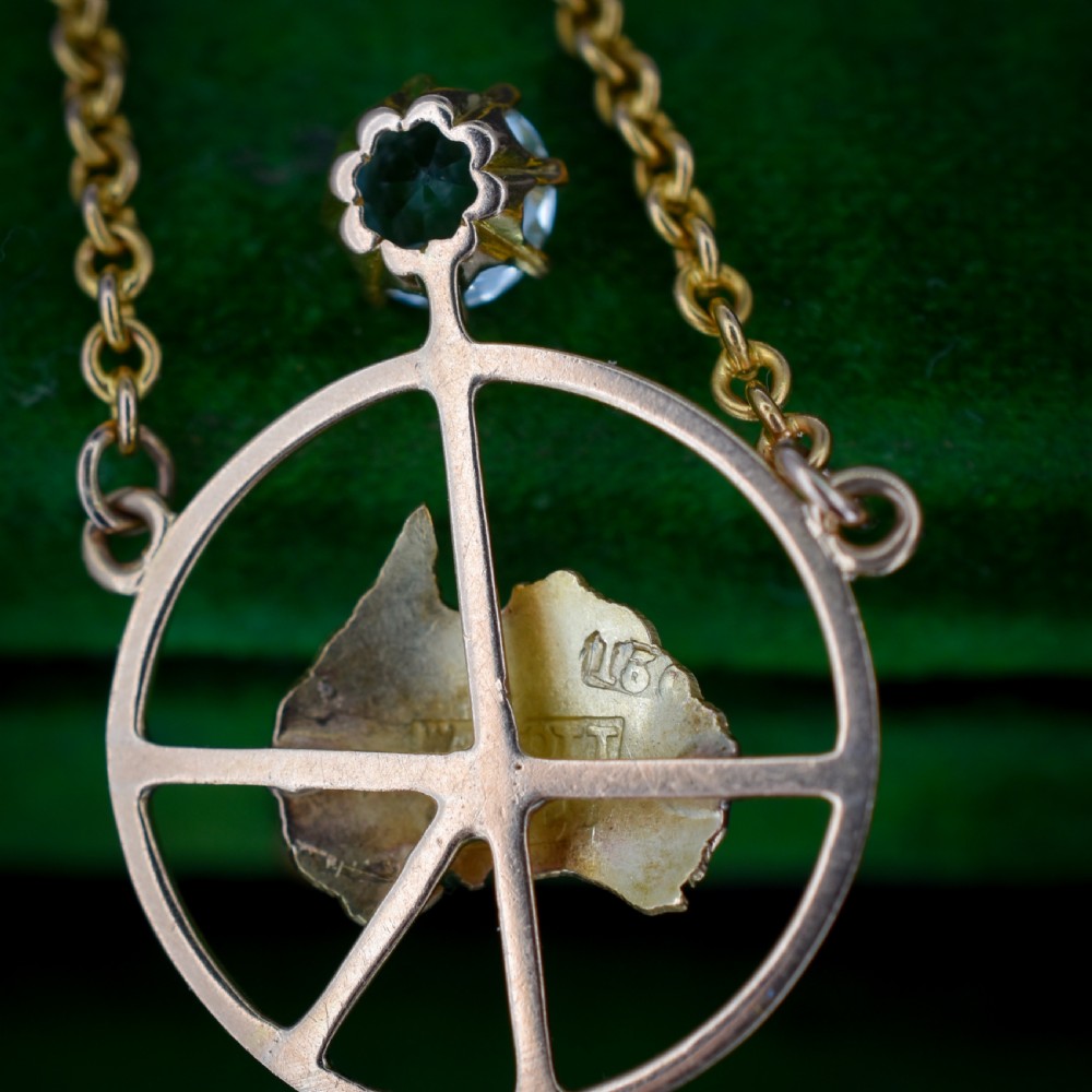 A 15ct yellow gold chain supporting a circular drop pendant featuring an Australian continent map cutout set between two round paste stones. View VII