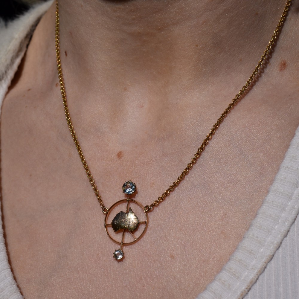 A 15ct yellow gold chain supporting a circular drop pendant featuring an Australian continent map cutout set between two round paste stones. View XII