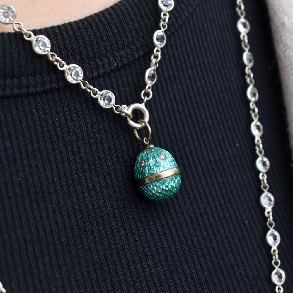 An egg-shaped silver charm pendant featuring vibrant turquoise blue guilloche enamel with fine engine-turned details and double silver mounting rings. View VIII