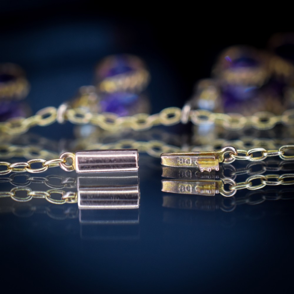 An antique gold fringe necklace featuring suspended pear-cut amethyst drops and seed pearls. View III