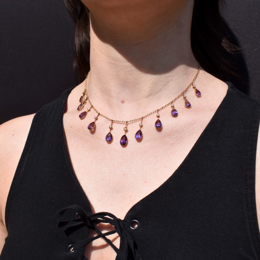 An antique gold fringe necklace featuring suspended pear-cut amethyst drops and seed pearls. View V