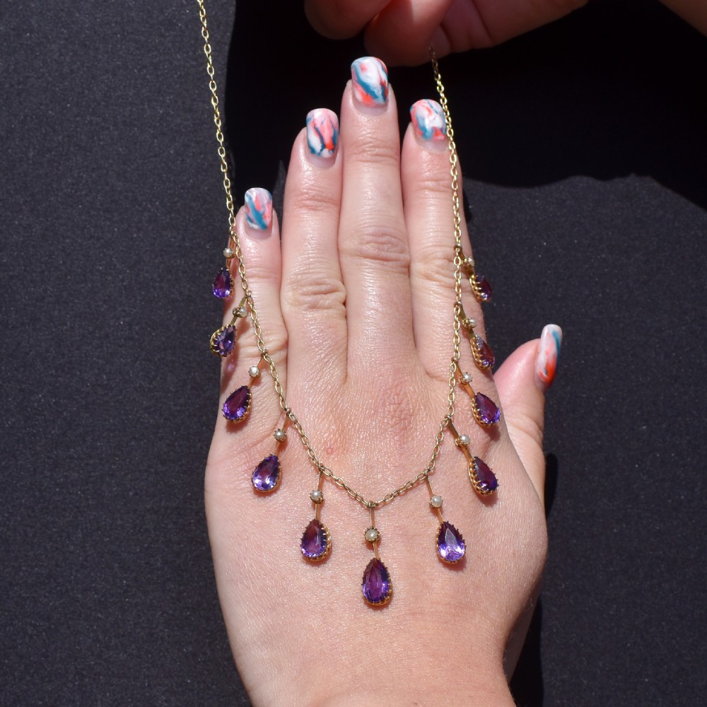 An antique gold fringe necklace featuring suspended pear-cut amethyst drops and seed pearls. View VI