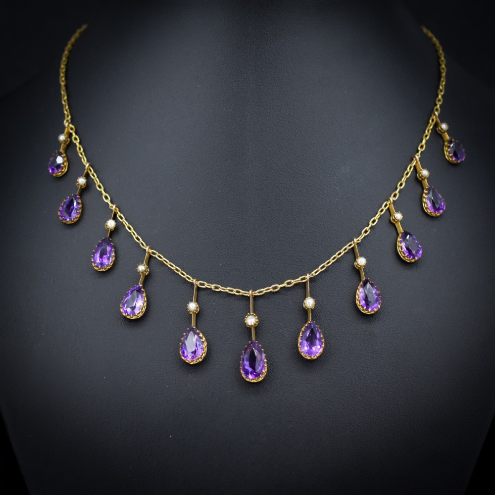 An antique gold fringe necklace featuring suspended pear-cut amethyst drops and seed pearls. View VIII