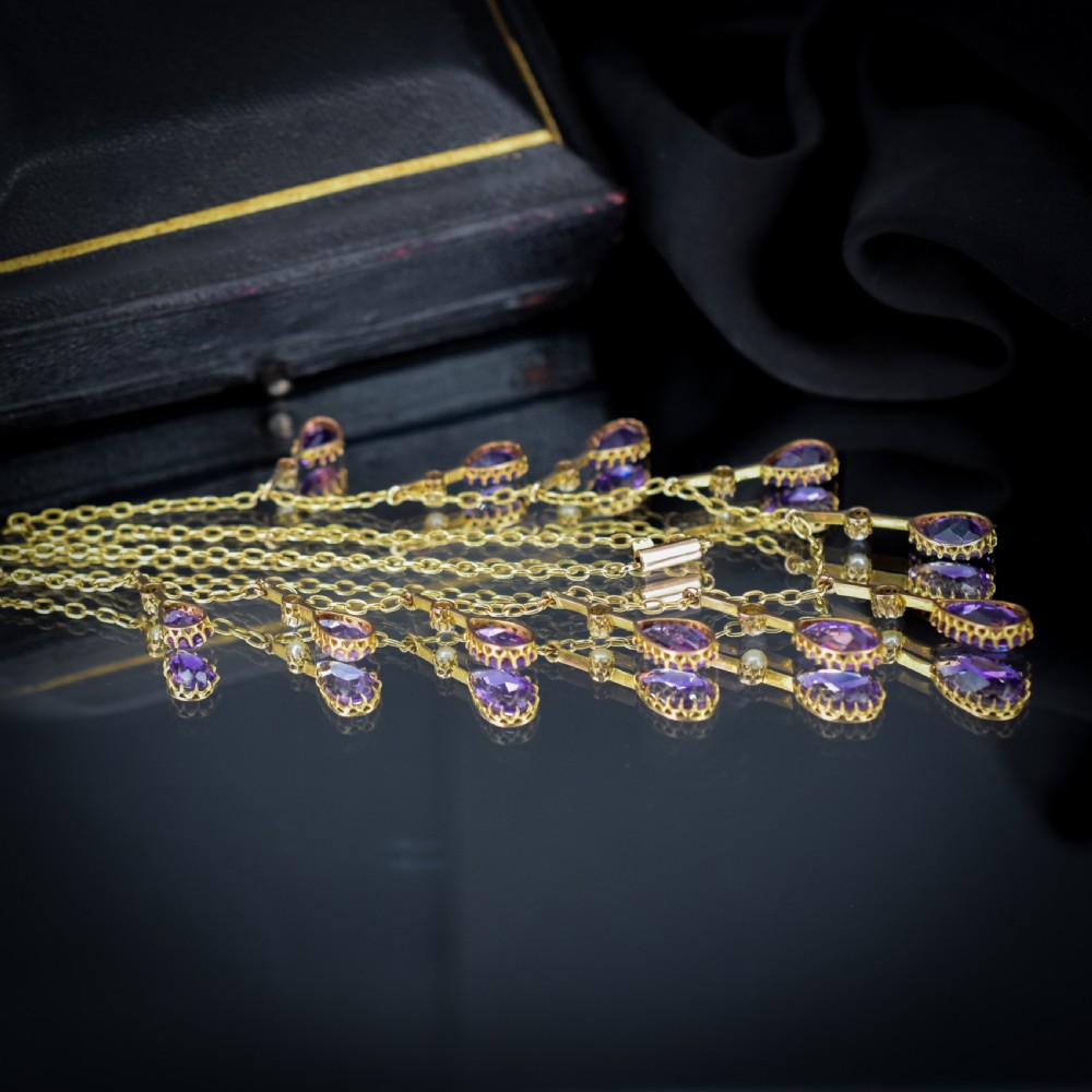 An antique gold fringe necklace featuring suspended pear-cut amethyst drops and seed pearls. View X