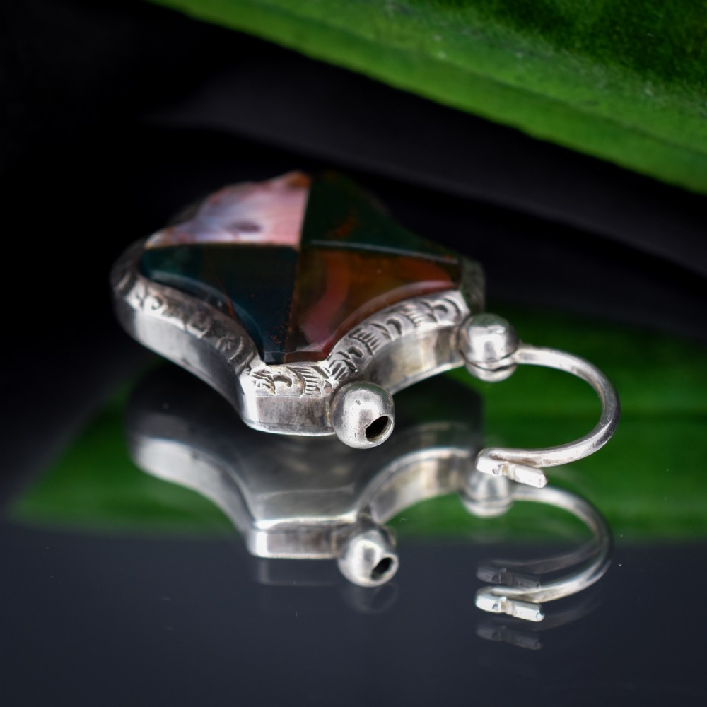 A Victorian silver padlock-shaped pendant featuring inlaid segments of red, green, and patterned agate with hand-engraved floral borders. View VII