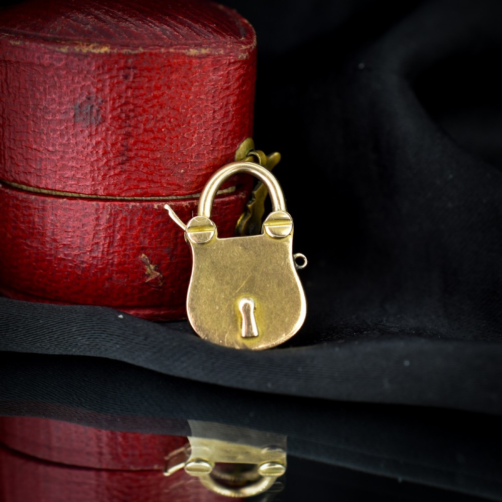 An antique 9ct yellow gold opening purse-style padlock charm featuring a keyhole motif and a hinged shackle. View II