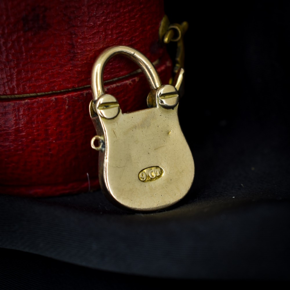An antique 9ct yellow gold opening purse-style padlock charm featuring a keyhole motif and a hinged shackle. View III
