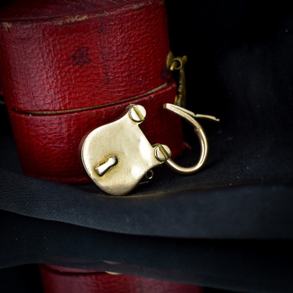 An antique 9ct yellow gold opening purse-style padlock charm featuring a keyhole motif and a hinged shackle. View IV