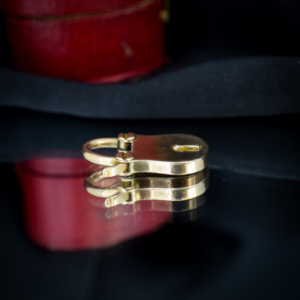 An antique 9ct yellow gold opening purse-style padlock charm featuring a keyhole motif and a hinged shackle. View VI
