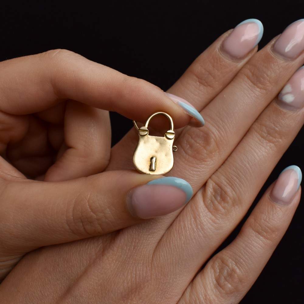 An antique 9ct yellow gold opening purse-style padlock charm featuring a keyhole motif and a hinged shackle. View VII