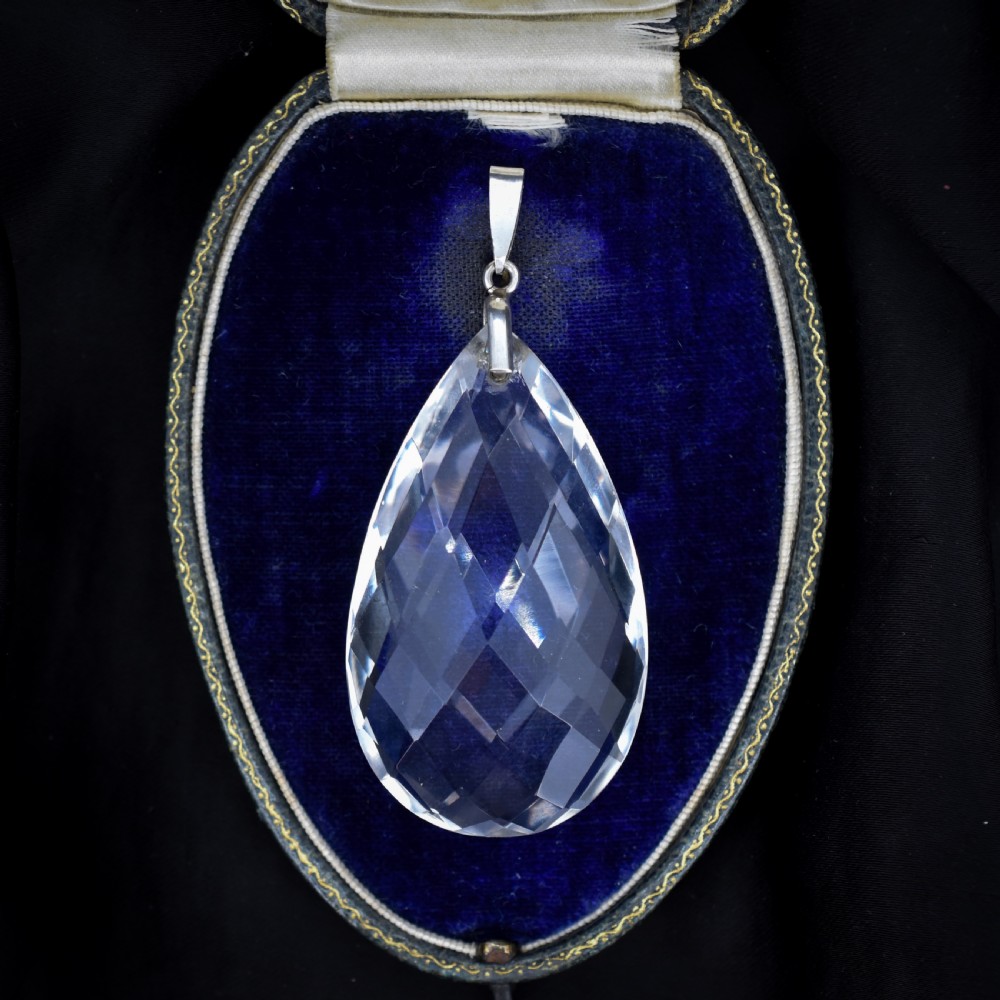 A large faceted pear-shaped clear rock crystal drop pendant featuring a sterling silver mounting loop.