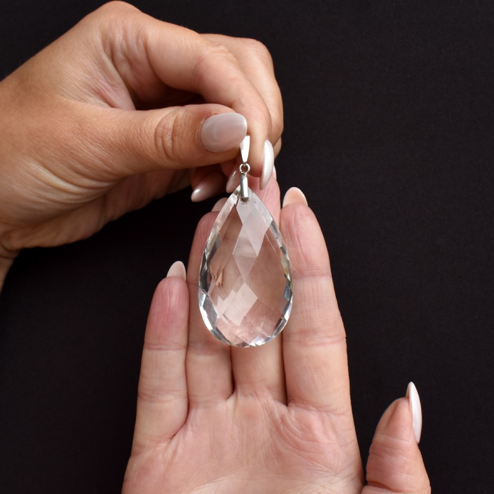 A large faceted pear-shaped clear rock crystal drop pendant featuring a sterling silver mounting loop. View II